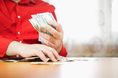 Erkek ellerinin bir yığın 100 dolarlık banknotları sayması. Bir iş adamı nakit sayar. Yatırım, para değişimi, rüşvet konsepti.