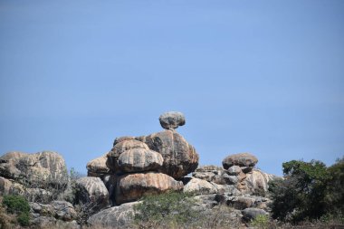 Mavi gökyüzüne karşı gri kayalar.