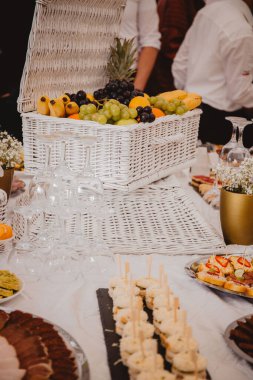 A vertical shot of decorative fruit basket for wedding on table with food