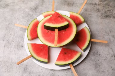 Karpuz buzlu şeker şeklinde kesilmiş.