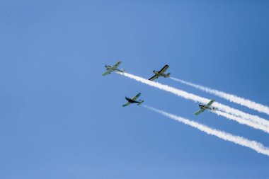 Mavi gökyüzünde dört uçak sergileniyor.