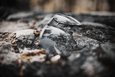 Parkta yerde duran siyah güneş gözlüğü.