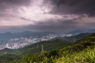 Kowloon şehri, Hong Kong, Çin 'de fırtınalı bulutlu bir gökyüzünün altında Lion Rock tepesinden duvarlarla çevrili.