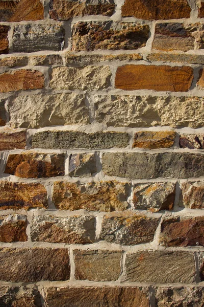A vertical closeup of an old brick wall.