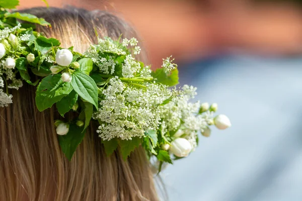 Woman with a flower wreath on her head. Midsummer celebration, a Swedish feast and tradition in June. Photography taken in Sweden, blurred background.