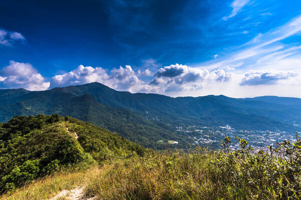 A beautiful view of mountain ranges and town underneath with cloudy sky in the background