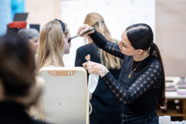 A lady getting her makeup done at BEA Expo in Bern, Switzerland
