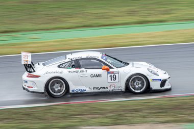 Islak pistte yarış arabası, yağmurlu bir günde. Porsche 911 Kupa 2018