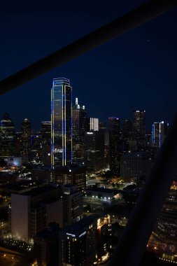 Gece yarısı Dallas, Teksas 'ta aydınlanmış modern gökdelenlerin dikey görüntüsü.