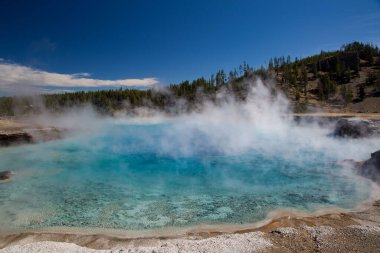 A beautiful landscape view of the Excelsior Geyser Crater in bright sunlight in Yellowstone National Park, Wyoming, United States