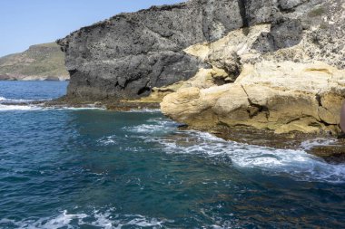 The coastal cliffs against the background of the blue sea.
