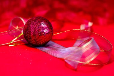 A closeup shot of a Christmas decoration on the red background