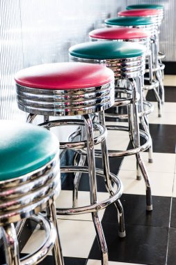 A vertical shot of a row of stools at a classic American 1950s style diner in Tennessee