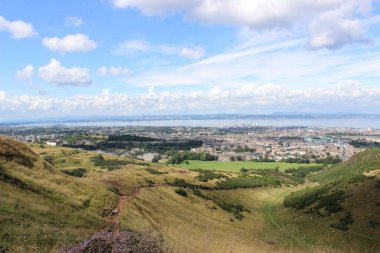 A beautiful scenery of the Arthur's Seat volcano hill with the cityscape in the background, Edinburgh, Scotland