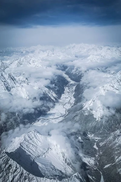 云下威严的雪峰的垂直空中景观 — 图库照片