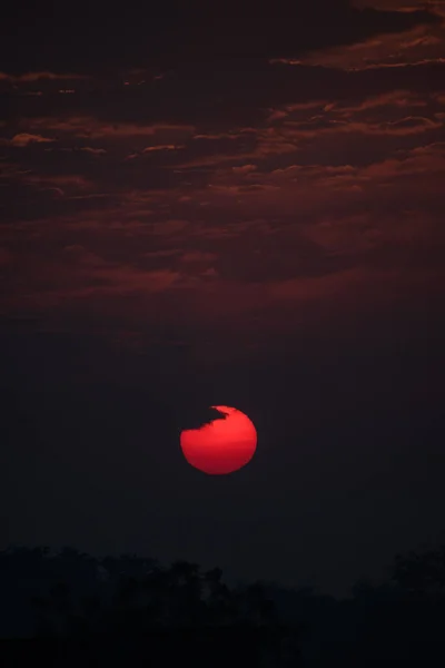 A beautiful view of red sun surrounded by clouds during sunrise in sky