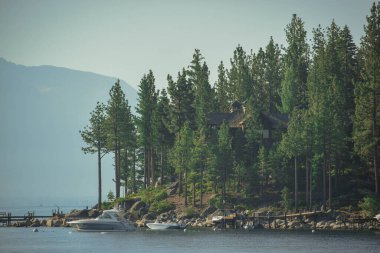 The view of the boat in the sea surrounded with the forest