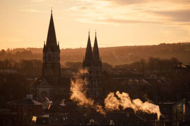 An aerial view of Cologne Cathedral surrounded by buildings during sunset