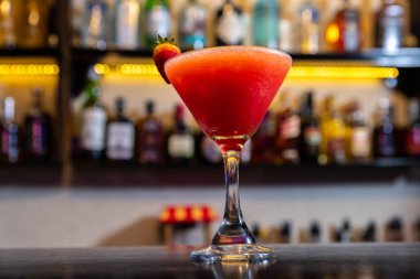 A closeup of a strawberry mocktail serve in a margarita glass on a table