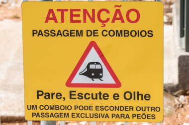 A Yellow caution warning information sign when crossing the train line with blurred background