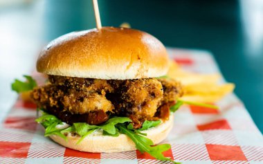 Arka planda patates kızartması ve vejetaryen köfteli burgerin yakın plan çekimi.