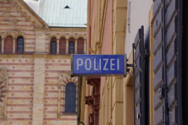 A shallow focus of a blue sign of a police office (Polizei ) on an old building