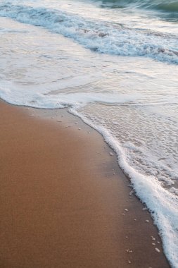White waves rolling in on a sandy beach on a summer day in Broadstairs, Kent,England.