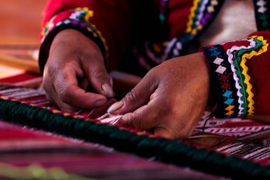 A close up of hands doing traditional Peruvian weaving