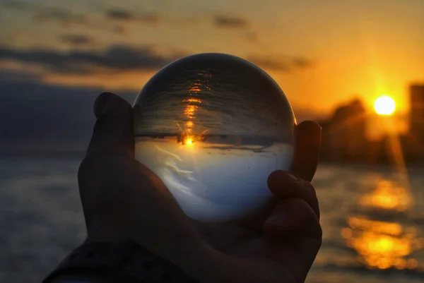 Closeup Shot Hand Holding Glass Ball Reflecting View Beach Sunset — Fotografia de Stock