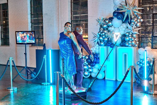Two People enjoying a 360 photo-video booth during a 40th Birthday celebration party