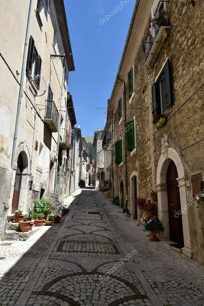 A vertical view of a cobblestone alley between medieval stone buildings