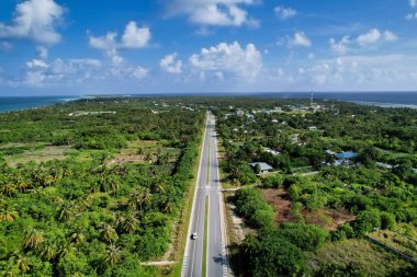 An aerial view of a road surrounded by fields on a sunny seaside