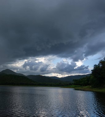 A vertical shot of a lake with a cloudy sky
