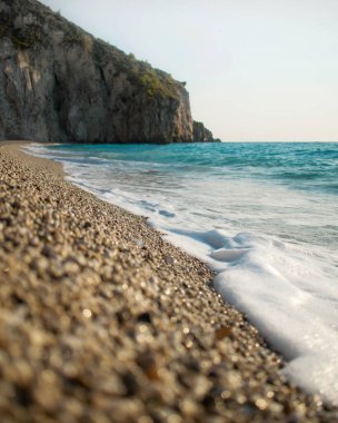 A beautiful view of sea waves coming to the beach on a sunny day