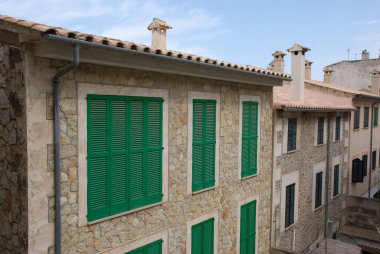 İspanya, Mallorca 'daki Akdeniz taş evinin yeşil kepenkleri.