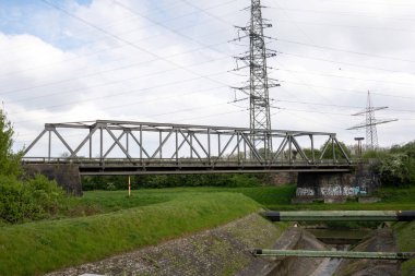 A bridge over Rhine Herne canal in the industrial area of Germany with an electric pylon in background