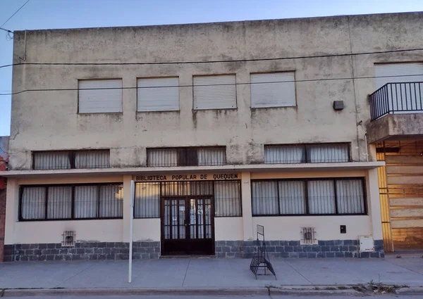 A view of an empty street against the facade of a popular library in Quequen, Buenos Aires