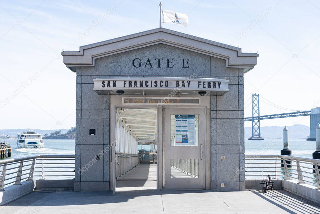 A San Francisco Bay Ferry Gate with a ferry and the San Francisco Bay Bridge in the background.