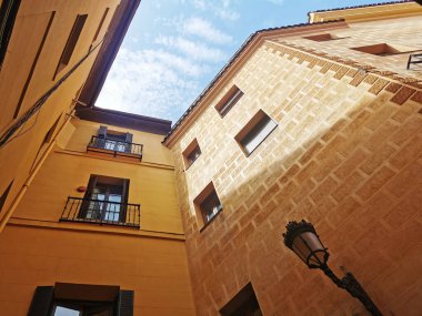 A low angle shot of tall yellow stone buildings in Madrid, Spain