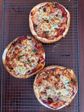 A vertical top view of three mini pizza Margheritas