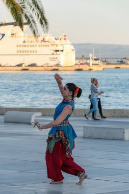 Bir kadın sokak sanatçısı, Hırvatistan 'ın Split kentinde gün ışığında el hareketleriyle geleneksel Asya dansını sergiledi.