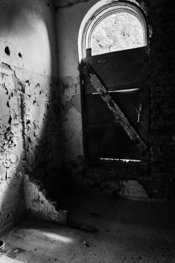 Terk edilmiş psikiyatri bölümü binasının iç kısmının dikey gri tonlu görüntüsü.