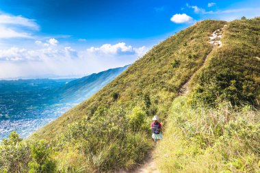Dağ sıralarının güzel manzarası ve altında bulutlu gökyüzü olan bir kasaba.