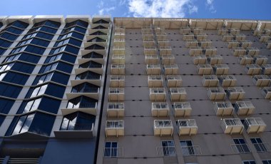 A low-angle shot of the facades of modern buildings against the blue sky. Fresno, United States.