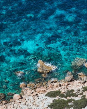 Ibiza 'daki Atlantis koyundaki parlak mavi suların dikey yüksek açılı görüntüsü.