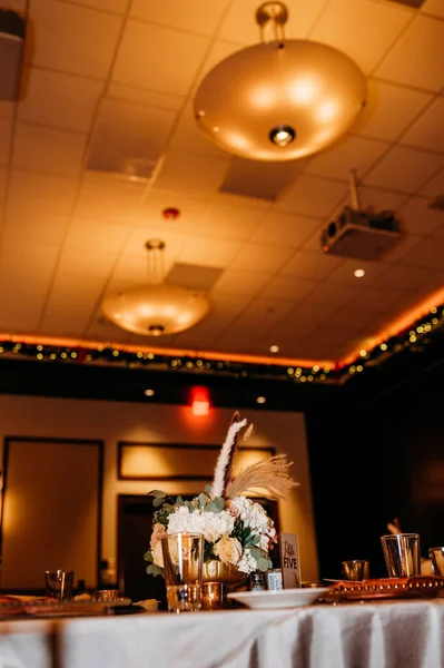 A vertical shallow focus shot of a table in a restaurant with a bouquet of roses