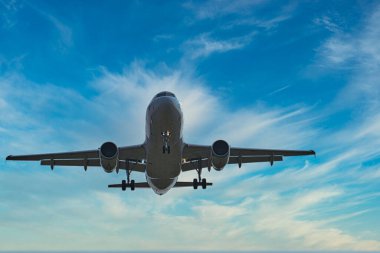 large passenger plane on approach for landing, front view, from below
