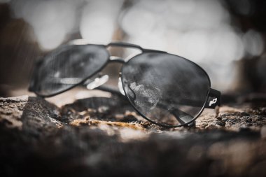 Parkta yerde duran siyah güneş gözlüğü.