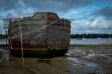An old rusty barge on the shoreline at Pin Mill, Suffolk, the UK