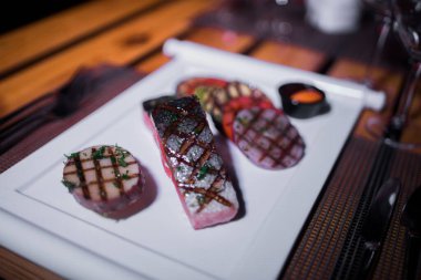 Izgara patates ve domatesli ızgara somon filetosu.